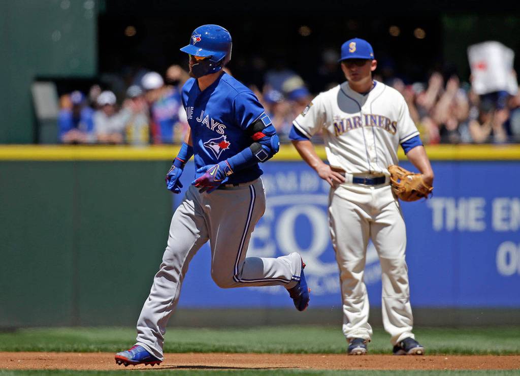 Toronto Blue Jays&rsquo; Josh Donaldson, left, rounds the bases on his home run as Seattle Mariners third baseman Kyle Seager looks on in the first inning of a baseball game Sunday, June 11, 2017, in Seattle. (AP Photo/Elaine Thompson)