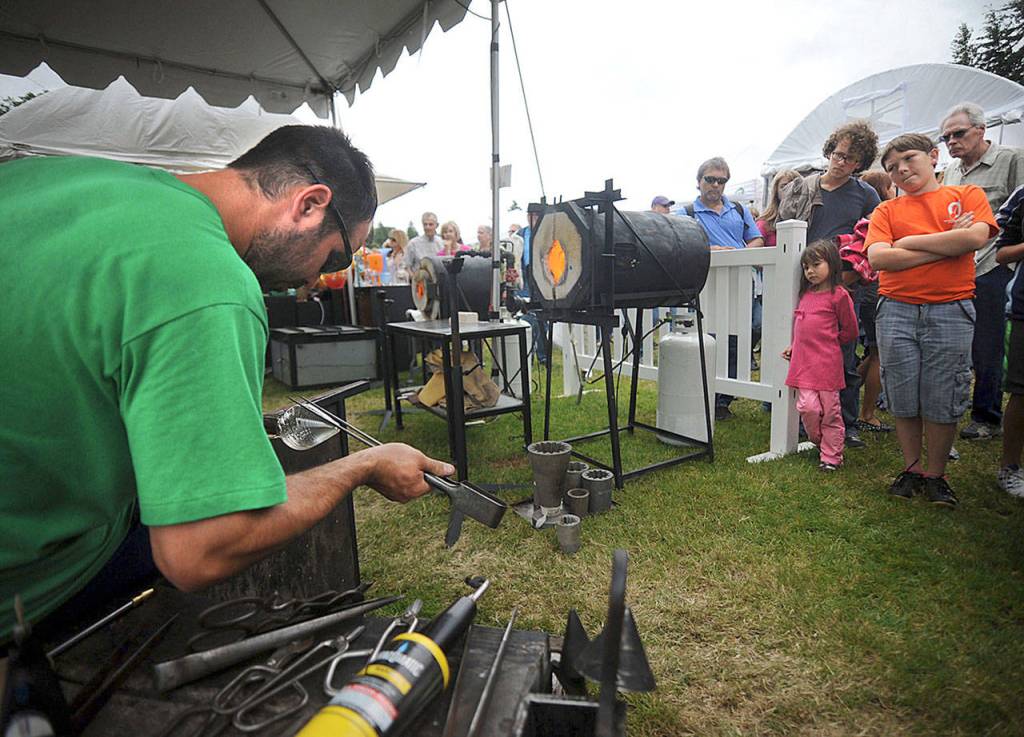 Glass blowing artist Chris Schuelke, of Edmonds, works on making a glass goblet during a demonstration at the 2012 Edmonds Arts Festival at the Frances Anderson Center. (For the Herald/Doug Ramsay)