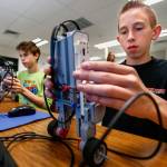 Granite Falls Middle School eighth-graders Howard Wilde (right foreground) and Jason Wad work at programming self-balancing EV3 robots so they will balance in a vertical stance while moving about. (Dan Bates / The Herald)
