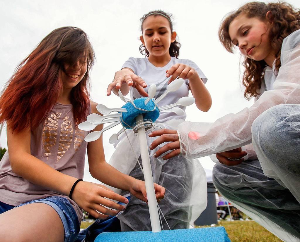 A team of three Haller Middle School sixth-graders nears completion on construction of a wind-turbine they created to generate power in a large mock Mars colony. The girls are (from left) Isabelle Gutierrez, Angelina Vasquez and Rihanna Sahnow. (Dan Bates / The Herald)