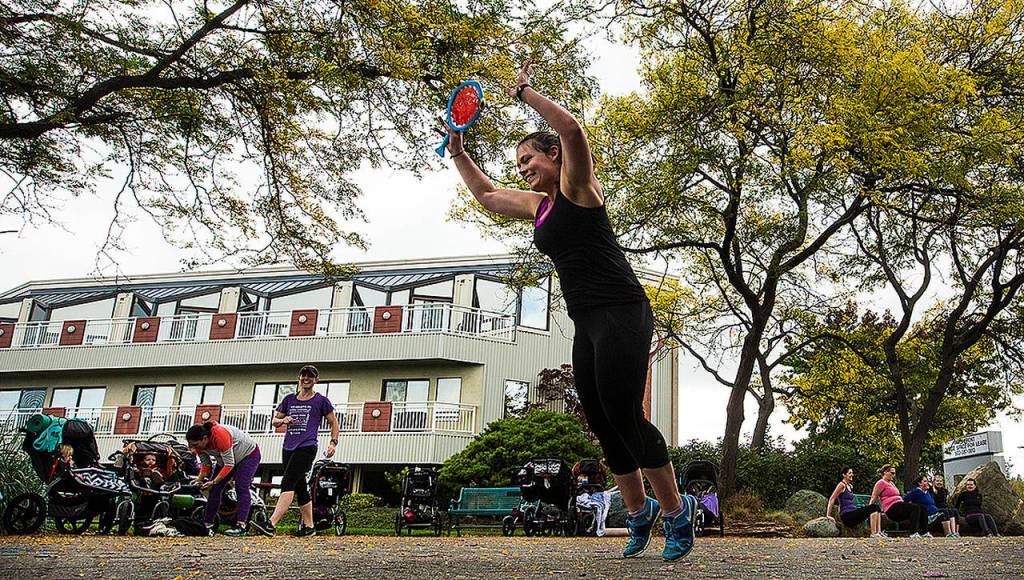 Under the yellowing leaves of a honey locust tree, Jenny Berke, of Edmonds, skips through exercises with other attendants of a Fit4Mom class in Edmonds. The class meets several times a week in downtown Edmonds and gives mothers a chance to get in a workout without leaving their little ones at home. (Ian Terry / The Herald)