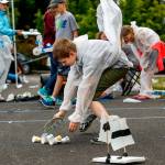 As sixth-grader T.J. Smith reaches for his lightweight wind-driven Rover, a gust of wind catches his space suit at a mock Mars colony he and fellow sixth-graders constructed outside Haller Middle School in Arlington on Monday. The Rover T.J. designed and built appeared to be doing well in wind-power-distance competition. (Dan Bates / The Herald)