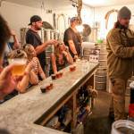Greg Krsak (far right), owner and operator of Scrappy Punk Brewery, pours samples. (Kevin Clark / The Herald)