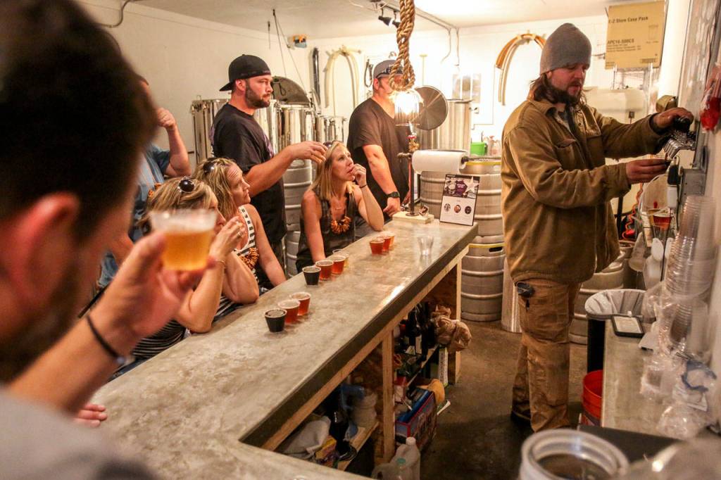 Greg Krsak (far right), owner and operator of Scrappy Punk Brewery, pours samples. (Kevin Clark / The Herald)