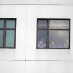 Those still inside the building peek out the windows after a shooting killing one and wounding six others at Bronx Lebanon Hospital Center on Friday in New York. (AP Photo/Michael Noble)