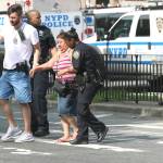 Police help people cross the street outside the Bronx Lebanon Hospital in New York after a gunman opened fire there on Friday. (AP Photo/Mary Altaffer)