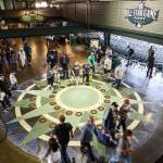 Baseball fans in the main concourse walk over the 27-foot diameter terrazzo compass rose, the icon of sea navigation and keystone of the Mariners logo. (Kevin Clark / The Herald)
