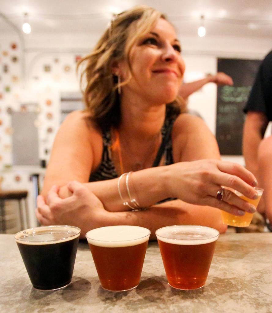 Megan Eison tries four samples at Scrappy Punk Brewery. (Kevin Clark / The Herald)