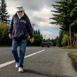 Williams walks a portion of his route along Third Avenue SE on Wednesday morning. (Dan Bates / The Herald)