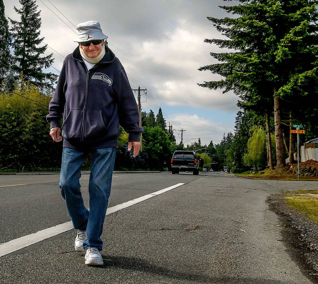 Williams walks a portion of his route along Third Avenue SE on Wednesday morning. (Dan Bates / The Herald)