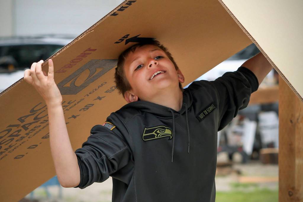 Logan Marson hauls cardboard for newly constructed garden beds at Eagle Ridge Park in Lake Stevens on June 3. (Kevin Clark / The Herald)