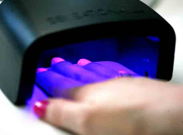 Instead of air drying, gel nail polish is cured under an LED light. (Vanessa McVay / The Herald)