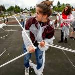 Kadie Harrett (center) is not just caught up in her work, but might have even torn her space suit as she and classmates attempt construction of a Mars habitat Monday outside Haller Middle School in Arlington, where sixth-graders spent the day building a mock Mars colony. (Dan Bates / The Herald)