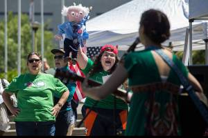 Holding a Bernie Sanders puppet, Leslie Zukor cheers as she and others sing along to the song &ldquo;Take It Personally&rdquo; sung by Tae Phoenix at an event called Stop Trumpcare Day at the Snohomish County Courthouse on Thursday in Everett. The protest was organized by Indivisible, an organization of some 6,000 community groups nationally. (Andy Bronson / The Herald)