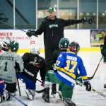 Everett Silvertips assistant coach Mitch Love (center) gives instruction with the help of Silvertips defenseman Wyatte Wylie (right) during a youth hockey camp at the Xfinity Arena Community Ice Rink on May 31. (Ian Terry / The Herald)