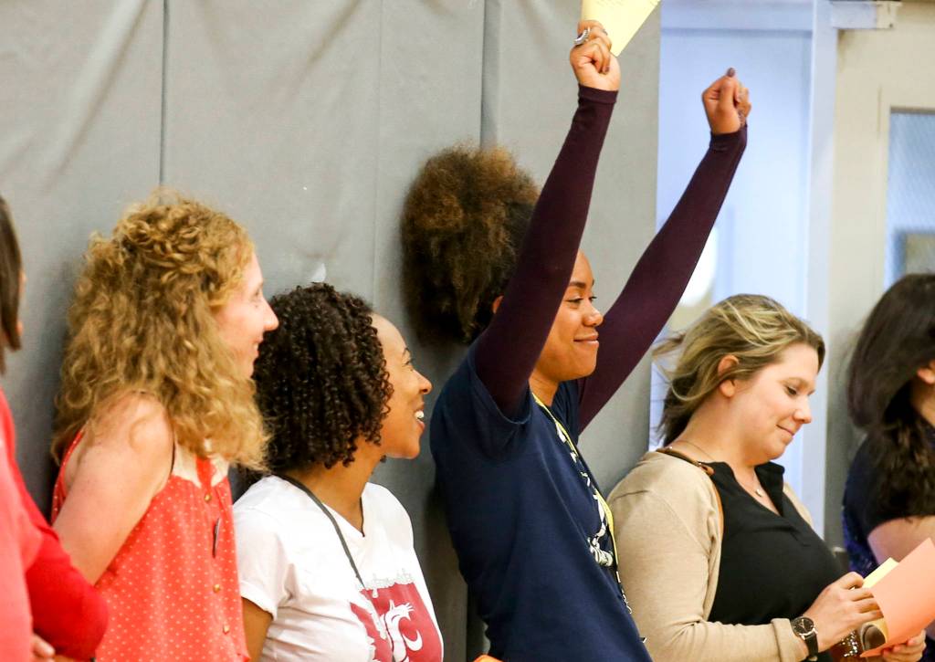 Jennifer Reyes celebrates the recycling of the ballots during the meeting of the Everett Education Association Thursday afternoon at Cascade High School Everett on June 1. (Kevin Clark / The Herald)