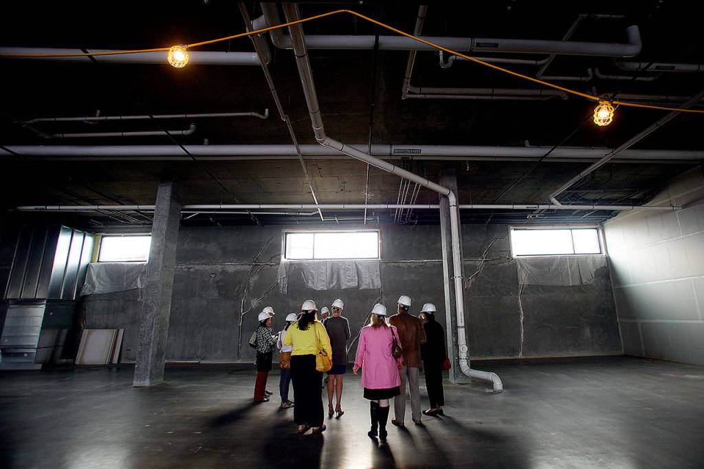 People get a sneak peek at an area that was to be a farmers market, at Potala Place, 2900 Grand Ave. in Everett, in April 2015. (Ian Terry / The Herald)