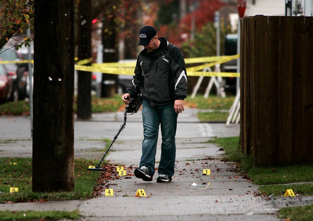 An Everett Police Department investigator searches for evidence at the scene of the shooting on Nov. 8, 2008. (Mark Mulligan / The Herald, file)