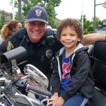 Officer Chuck Freeman with a child at the Lynnwood Police Department&rsquo;s fourth annual Cops and Kids event. About 1,000 people stopped by the Alderwood mall plaza to meet officers and learn about their jobs. Photo credit: Linda Deppa