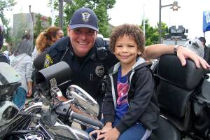 Officer Chuck Freeman with a child at the Lynnwood Police Department&rsquo;s fourth annual Cops and Kids event. About 1,000 people stopped by the Alderwood mall plaza to meet officers and learn about their jobs. Photo credit: Linda Deppa