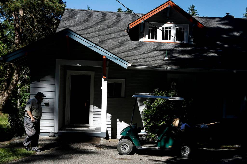 Kayak Point Park campground host Lamont Olson walks back to his cart after checking on a rental cabin at the Stanwood park on June 22. (Ian Terry / The Herald)