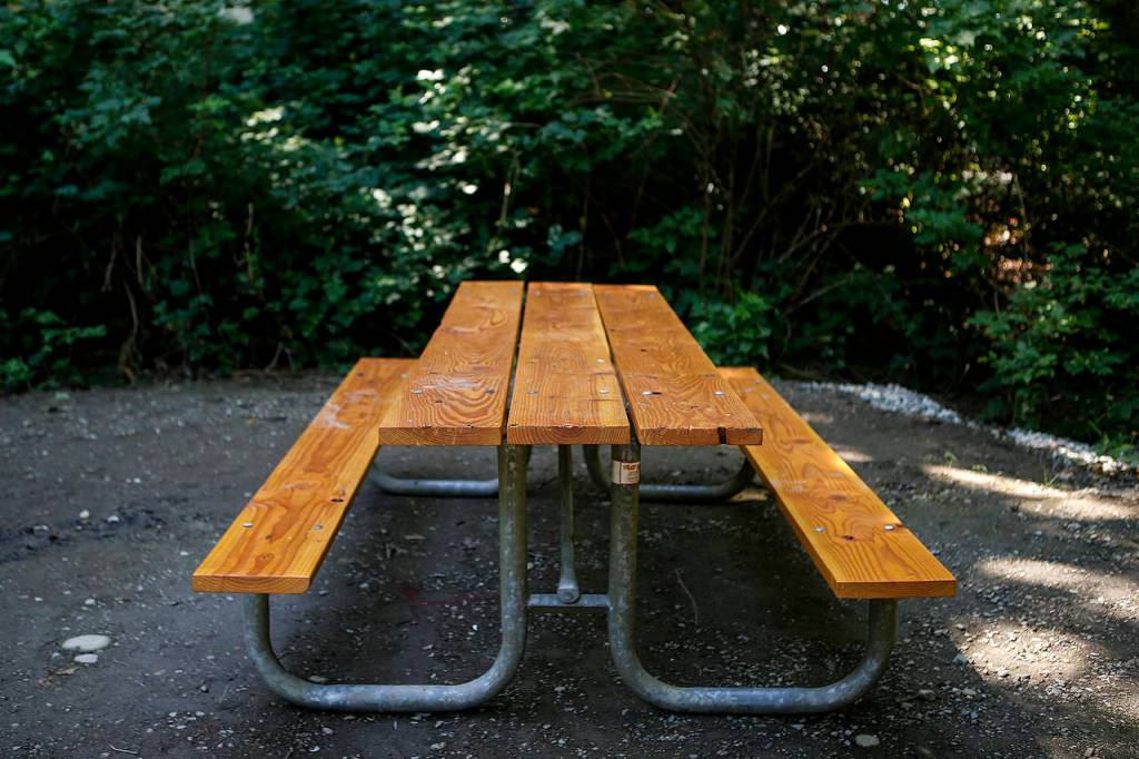 A picnic bench, newly restored by Kayak Point campground host Lamont Olson, is seen in a camping space. (Ian Terry / The Herald)