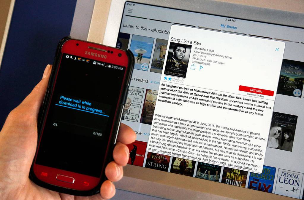 &ldquo;Sting Like a Bee,&rdquo; a biography of Muhammad Ali, is being downloaded a cellphone using a Cloud Library ebook kiosk recently installed by the Everett Public Library at Everett Station. (Dan Bates / The Herald)
