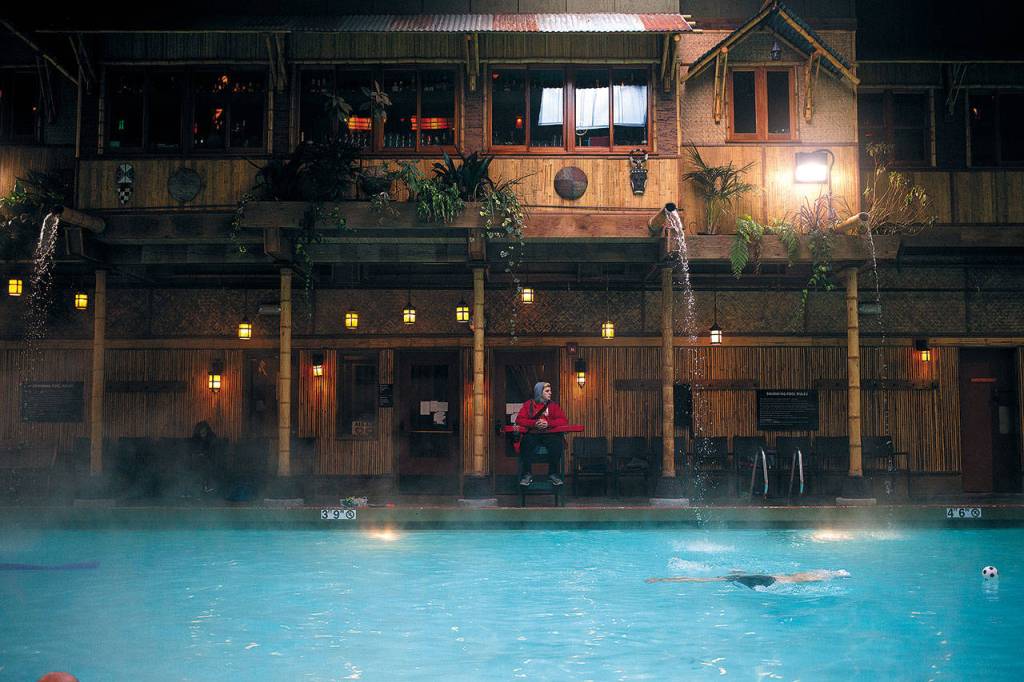 Lifeguard Alex Beyers watches over swimmers in the pool at McMenamins Anderson School in Bothell on March 8. Bothell residents can swim for free. (Andy Bronson / The Herald)