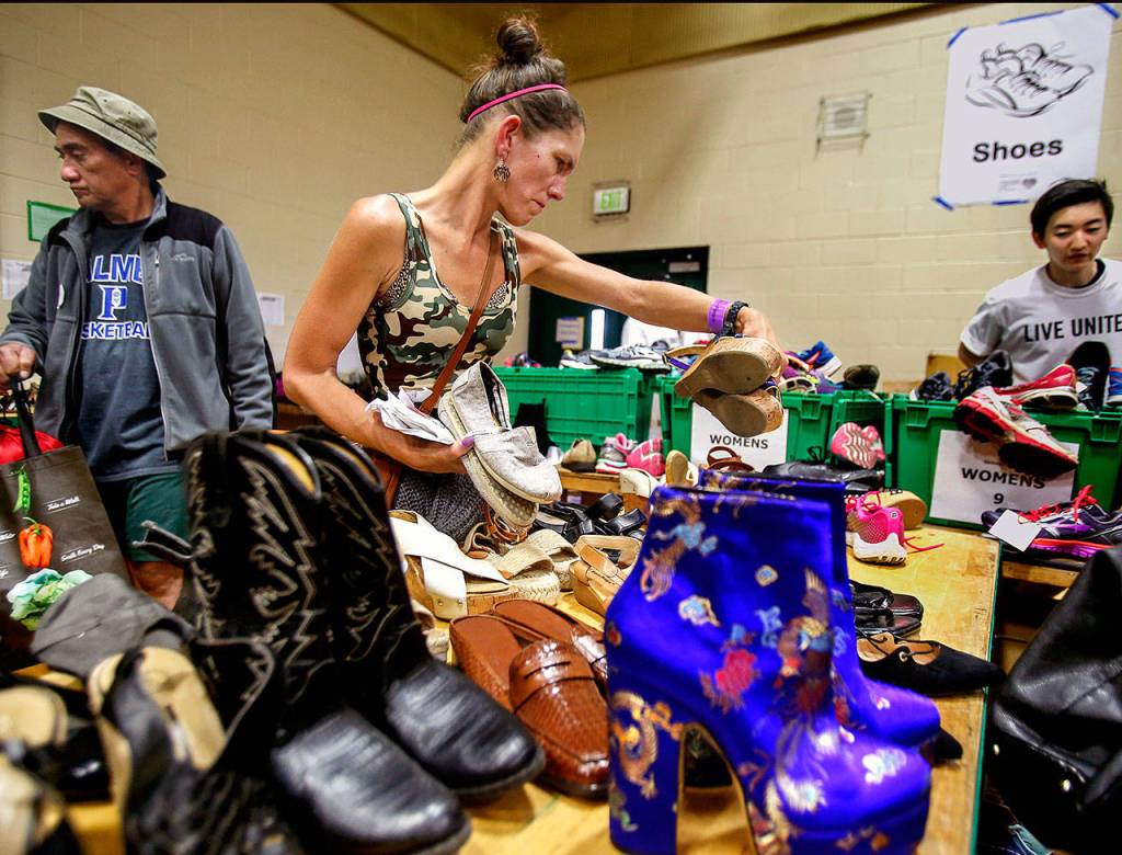 Diana Severich, 41, picks out some shoes Thursday at Project Homeless Connect. Severich, who said she &ldquo;loves shoes,&rdquo; has been living in a tent the past year with her boyfriend. (Dan Bates / The Herald)