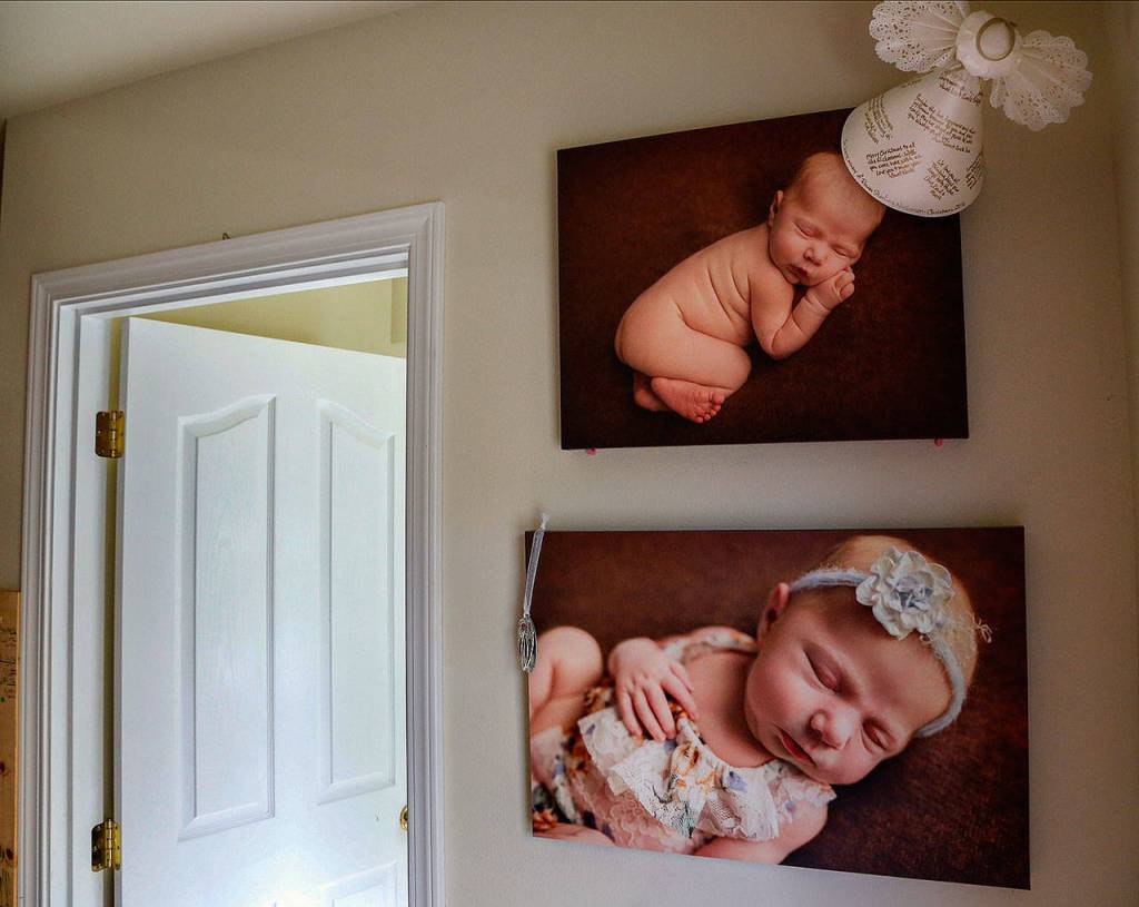 A paper angel signed by loved ones is displayed with enlarged photos of baby Rowan as a newborn. The angel topped the family Christmas tree just months after Rowan died. (Dan Bates / The Herald)
