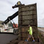 Justin Hottel inspects the locks on garbage containers in Everett on a train recently bound for Eastern Washington. (Ian Terry / The Herald)
