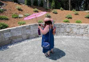 Karla Hailer, a fifth grade teacher from Situate, Massachusettes, makes a video of the Proctor&rsquo;s Ledge Memorial before the noon dedication of the site Wednesday where five women were hanged as witches 325 years ago during the Salem witch trials. (Stephan Savoia / Associated Press)