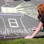 Rachel Leavitt decorates a walkway Sunday at Lighthouse Park in Mukilteo to remember the three young people killed and another injured one year ago. (Kevin Clark / The Herald)