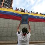 In this July 24 photo, an anti-government demonstrator holds up an image of Venezuela&rsquo;s constitution during a tribute to those killed during protests against Venezuela&rsquo;s President Nicolas Maduro, in Caracas, Venezuela. (AP Photo/Fernando Llano, File)