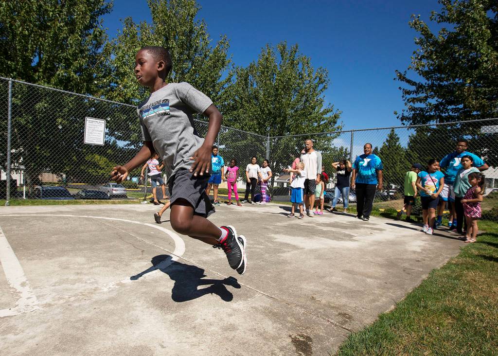 Jaden Nelson hops on one foot during a YMCA-led relay race July 26 in Marysville. (Andy Bronson / The Herald)