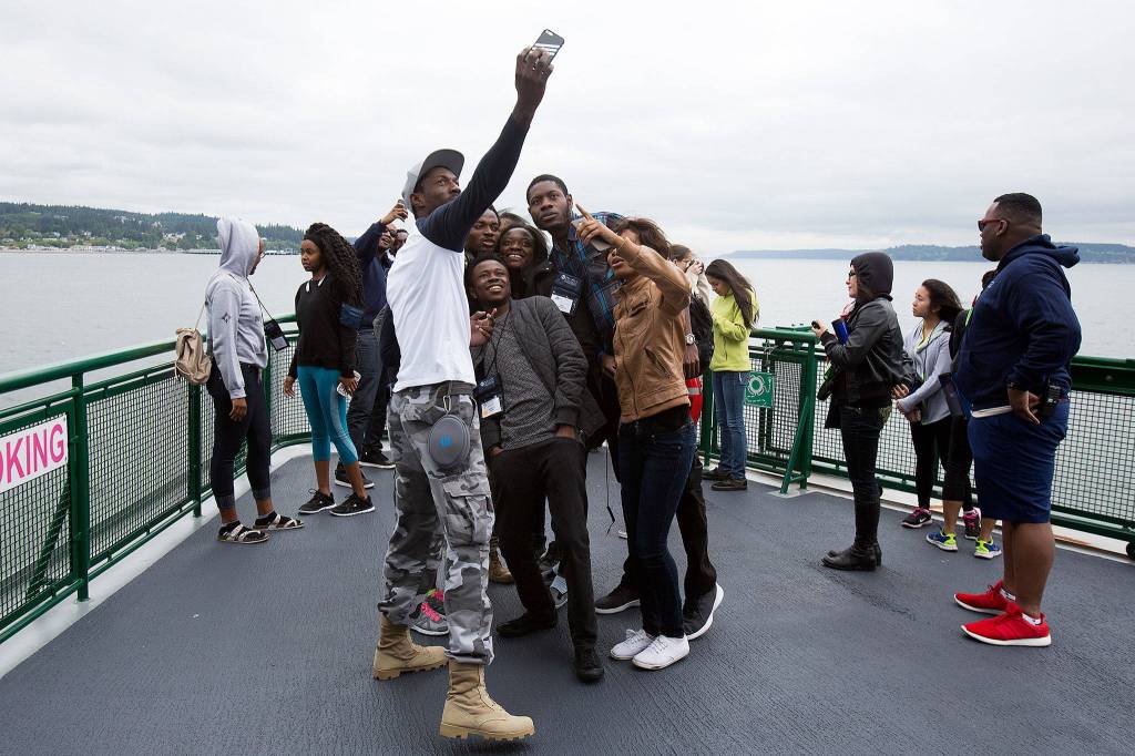 French-speaking visitors take a selfie together aboard a ferry on the Mukilteo/Clinton run on June 21. (Andy Bronson / The Herald)