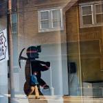 A mural of a coal miner stands in an empty storefront as signs advertising vacant apartments and stores hang in the windows along the main business street in Cumberland, Ky in October, 2014. (David Goldman/Associated Press file photo)