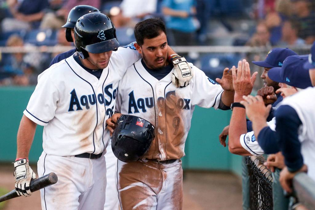 Everett&rsquo;s Johnny Adams (left) congratulates Eugene Helder after Helder stole home Wednesday night at Everett Memorial Stadium. (Kevin Clark / The Herald)