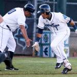 Everett AquaSox manager, Jose Moreno, low-fives Joseph Rosa after a home run single in the third inning against the Vancouver Canadians Monday night at Everett Memorial Stadium. (Kevin Clark / The Herald)
