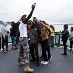 French-speaking visitors take a selfie together aboard a ferry on the Mukilteo/Clinton run. (Andy Bronson / Herald file)