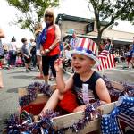 Jackson Emerick, 4, of Shoreline, tosses candy out to crowds lining Main Street in downtown Edmonds during An Edmonds Kind of 4th parade Tuesday. (Ian Terry / The Herald)