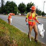 Seasonal Snohomish County workers Kyle Schuman (right) and Dakota Scherrer pick up trash along Marine Drive in Marysville on June 28. (Ian Terry / The Herald)