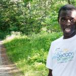 Moninda Marube points to the house on Whitman Spring Trail in Auburn, Maine, while recounting his encounter with a pair of bears that chased him. Marube, a professional runner from Kenya, said he had to outrun the two charging bears while training in the woods Wednesday. (Russ Dillingham / The Lewiston Sun-Journal)