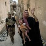 A woman holds a young injured girl as Iraqi forces continue their advance against Islamic State militants in the Old City of Mosul, Iraq, on Monday. (AP Photo/Felipe Dana)