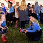 St. Paul Rodeo Princess Morgan Spear talks to Jolie Thomas, 3, at a St. Paul Rodeo barbecue last mont. Thomas told Spear that she wants to be a rodeo queen when she grows up. (Molly J. Smith / Statesman-Journal)