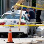 An official photographs the scene where police say a taxi driver struck a group of pedestrians, injuring several, on Monday in Boston. (AP Photo/Michael Dwyer)