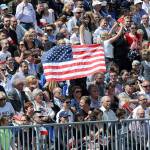 Poles hold a Unites States flag while waiting for U.S. President Donald Trump to deliver a speech in Krasinski Square in Warsaw, Poland, on Thursday. (AP Photo/Alik Keplicz)