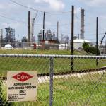 In this 2014 photo, a sign is posted on a roadside fence outside a Dow Chemicals plant in Freeport, Texas. (AP Photo/Pat Sullivan, File)