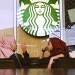 Malaysian Muslim women chat at Starbucks Coffee shop in Rawang outside Kuala Lumpur, Malaysia, on Thursday. (AP Photo/Daniel Chan)