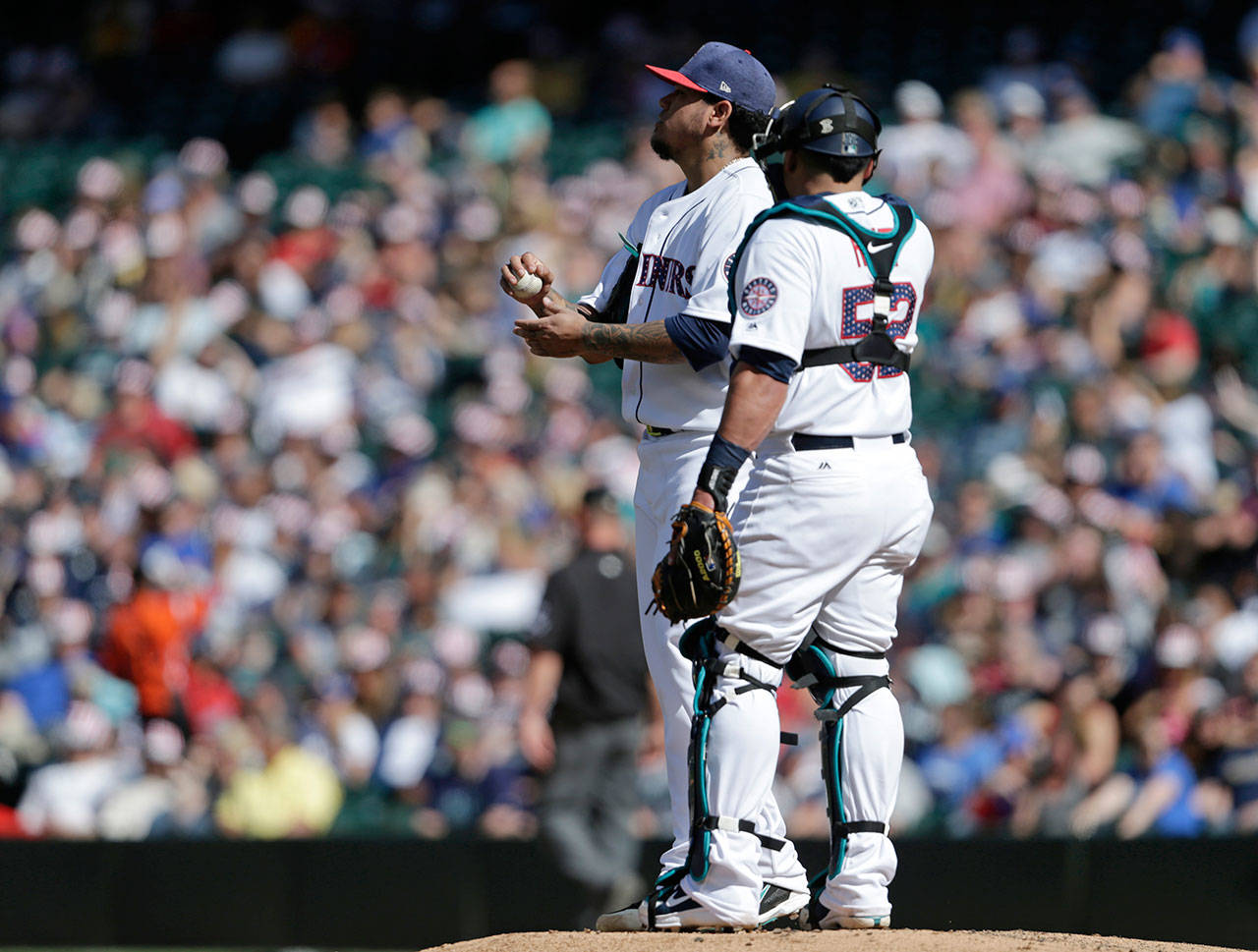 Mariners starting pitcher Felix Hernandez talks with catcher Carlos Ruiz after giving up a home run against the Royals during a game on July 4, 2017, in Seattle. (AP Photo/John Froschauer)